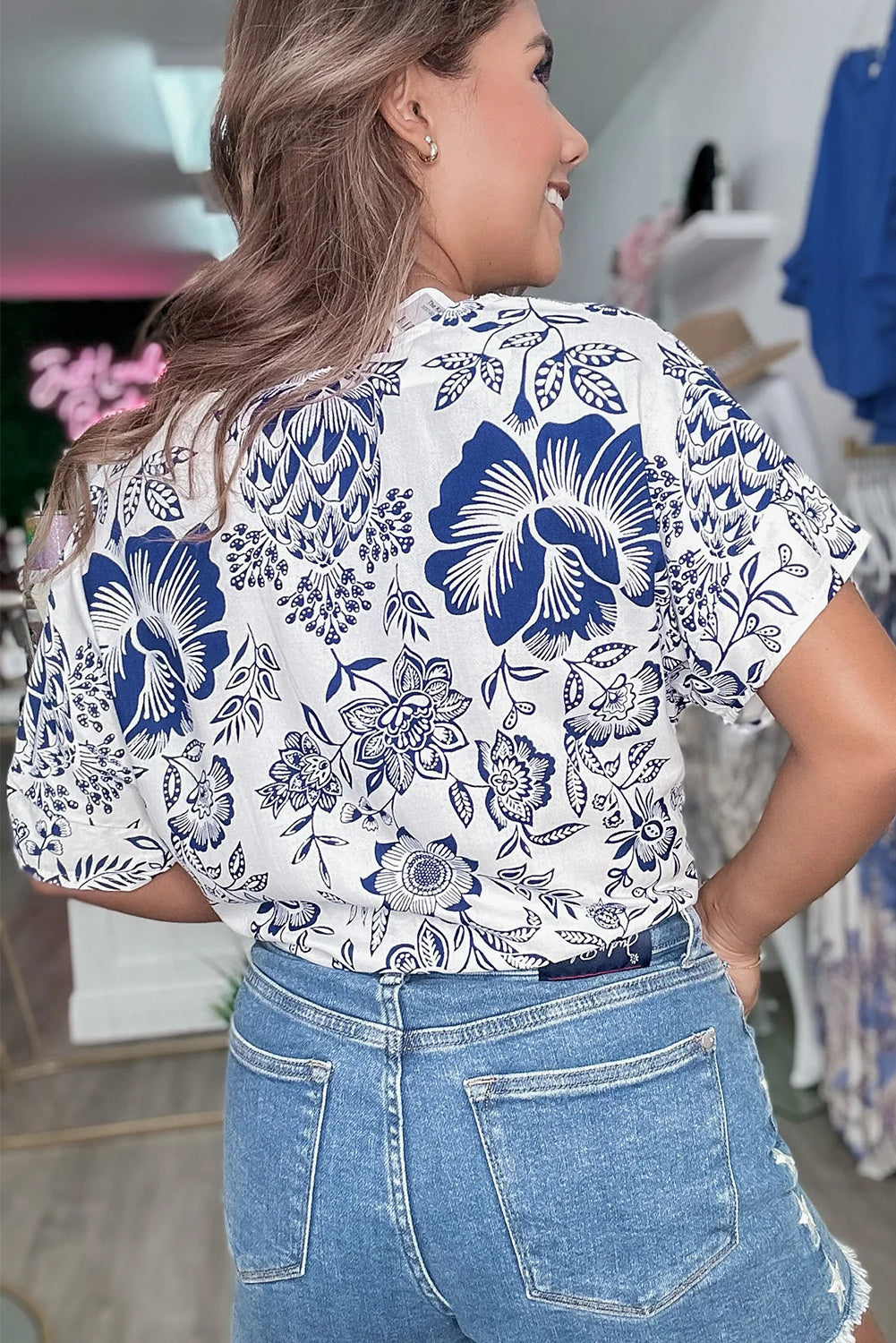 Blouse florale bleue coupe ample à col en V et ourlet noué