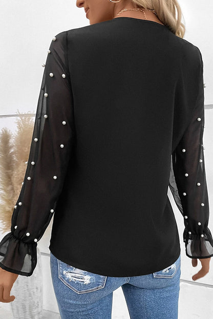 Blouse noire à col en V et manches en maille perlée