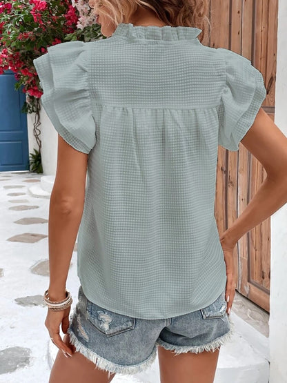 Blouse à volants et mancherons crantés